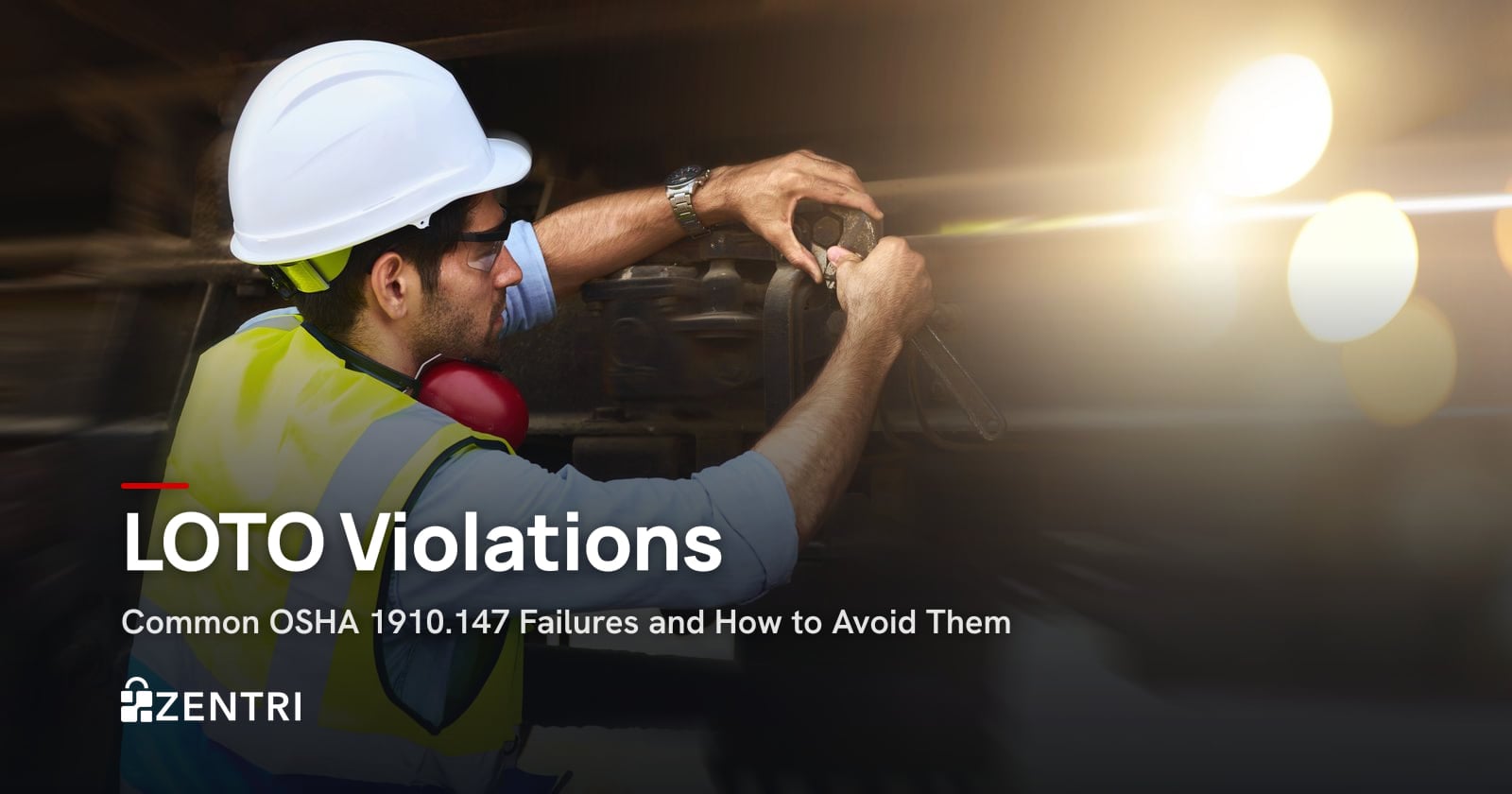 Maintenance technician in a hard hat using a wrench on industrial equipment