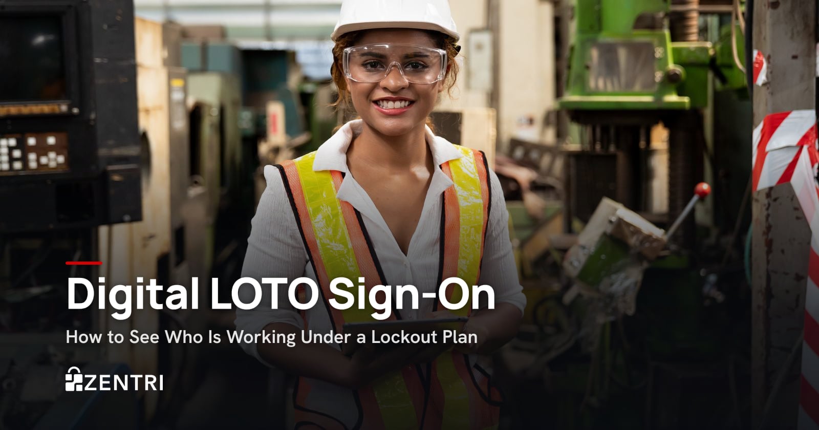 Smiling factory worker in a hard hat and hi-vis vest at a machine