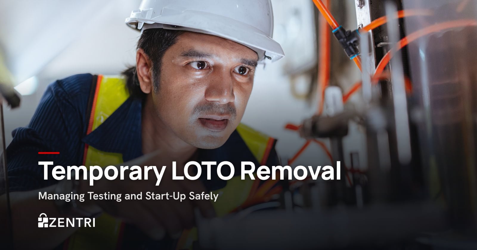 Technician in a hard hat working on machine wiring during start-up